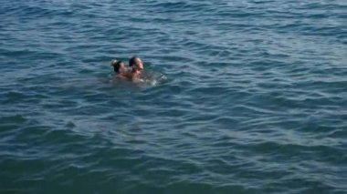 Sarılma ve suda denizde öpüşme oyun güzel kadın ve erkek. 4k, ağır çekim