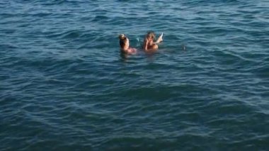 Sarılma ve suda denizde öpüşme oyun güzel kadın ve erkek. 4k, ağır çekim