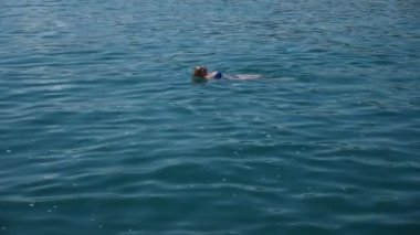 Sarışın güzel kadının açık deniz, suda yüzen. Yukarıdan görüntüleyin. Ağır çekim.