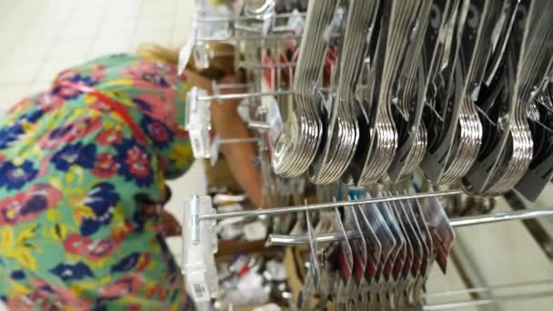 Giovane donna sceglie utensili da cucina nel supermercato, 4k. Rallentatore — Video Stock