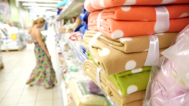 Ung flicka att välja bad handdukar textil i kläder kläder shop stormarknad, 4k. Slow motion — Stockvideo