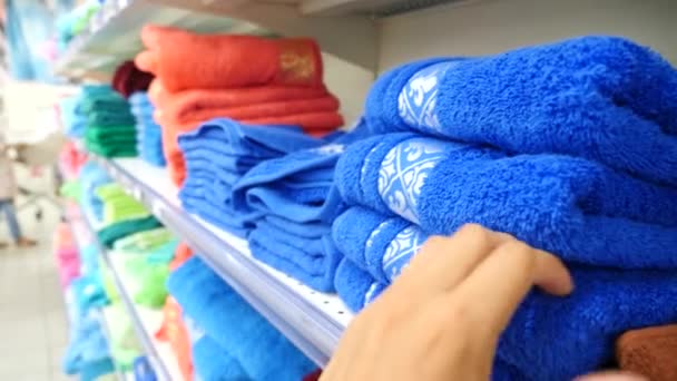 Chica joven eligiendo toallas de baño textil en ropa ropa tienda supermercado, 4k. Movimiento lento — Vídeo de stock