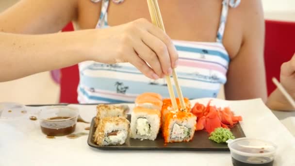 Mujer caucásica comiendo sushi en un restaurante — Vídeos de Stock