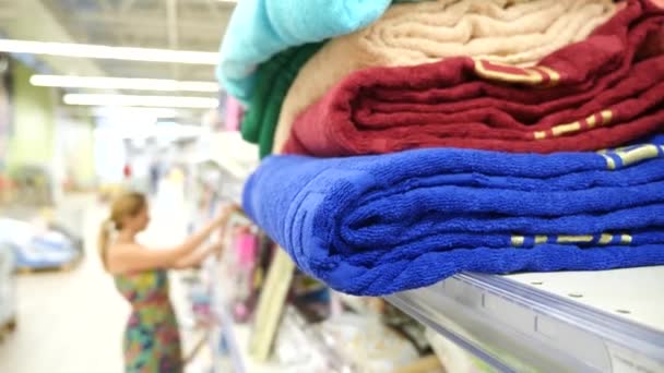 Junges Mädchen wählt Badetücher Textil in Bekleidungsgeschäft Supermarkt, 4k. Zeitlupe — Stockvideo