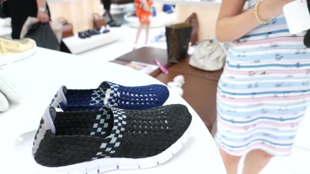 Blonde vrouw kiest schoenen in een schoen boetiek, 4k, slow-motion — Stockvideo