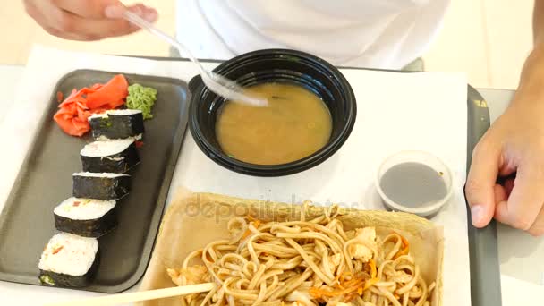 Un uomo mangia cibo cinese in un fast food. 4k. Rallentatore . — Video Stock