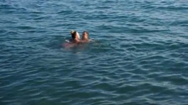 Sarılma ve suda denizde öpüşme oyun güzel kadın ve erkek. 4k, ağır çekim