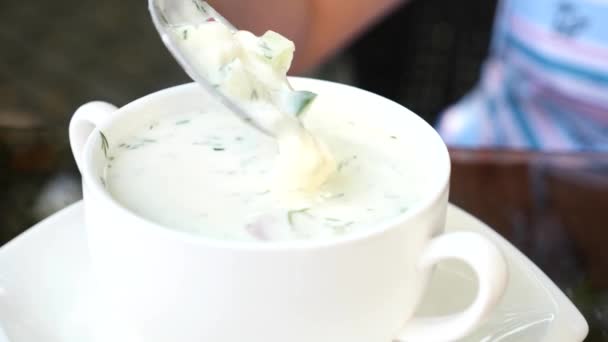 Okroshka sobre el kéfir - la sopa rusa fría y las manos mezclan la sopa con la cuchara. 4k, primer plano, cámara lenta . — Vídeos de Stock