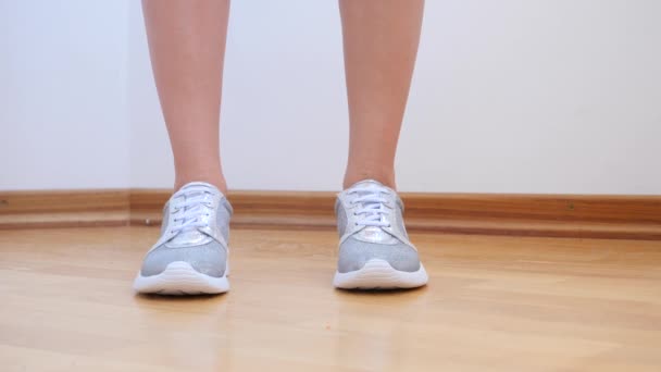 Een sexy vrouw in zilveren sneakers neemt van haar slipje. 4 k. Slowmotion. — Stockvideo