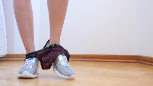 Een sexy vrouw in zilveren sneakers neemt van haar slipje. 4 k. Slowmotion. — Stockvideo