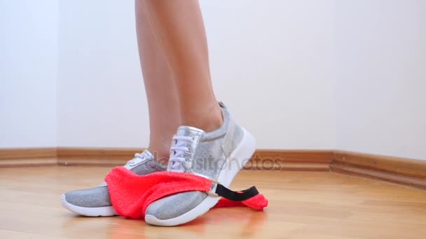 Een sexy vrouw in zilveren sneakers neemt van haar slipje. 4 k. Slowmotion. — Stockvideo