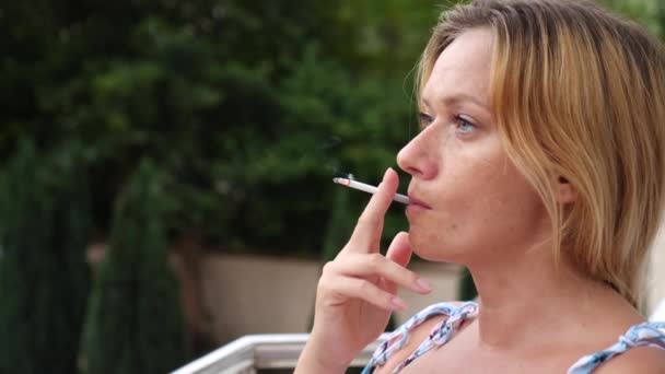 Una mujer fuma en el verano en la calle cigarrillos finos. 4. En cámara lenta. — Vídeos de Stock