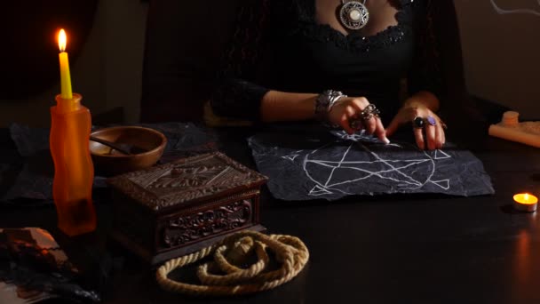 La sorcière est une diseuse de bonne aventure avec des bougies en gros plan. Un rituel magique. divination. Halloween, 4k, ralenti — Video