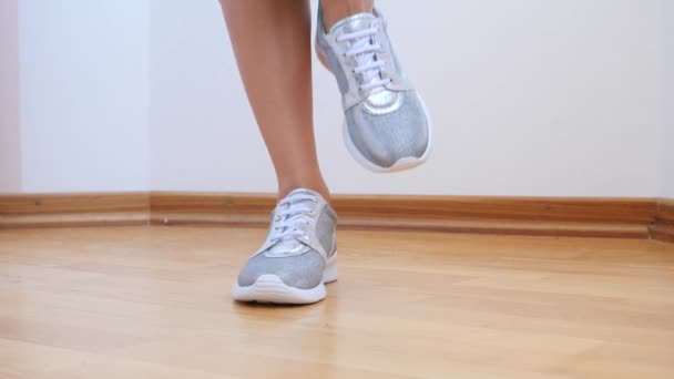 Een sexy vrouw in zilveren sneakers neemt van haar slipje. 4 k. Slowmotion. — Stockvideo