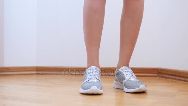 En sexig kvinna i silvrig sneakers tar av trosorna. 4 k. slowmotion. — Stockvideo