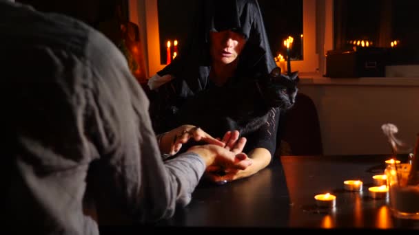 Die Hexe ist eine Wahrsagerin mit Kerzen in Großaufnahme. ein magisches Ritual. Wahrsagerei. Halloween, 4k, Zeitlupe — Stockvideo