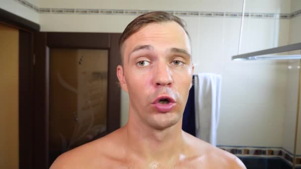 Bir adam şarkı söylüyor ve bir ayna banyodaki yakınındaki bir sabah tuvalet sırasında dans ediyor. 4k, ağır çekim — Stok video