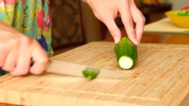 Eller bir bıçakla bir salatalık bir ahşap tahta üzerinde oyulmuş. 4 k. ağır çekim