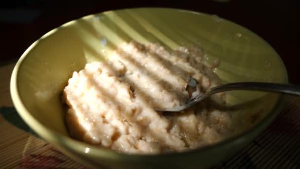 Einen Teller mit Haferflocken und schmelzender Butter. vor dem Hintergrund des Schattens der Jalousien. Frühstück zu Hause. 4 k. Zeitlupenschießen — Stockvideo
