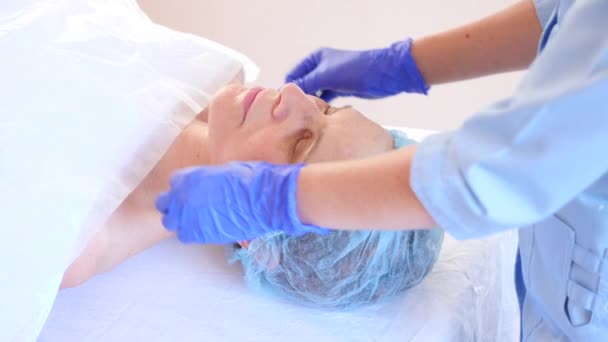 Spa therapy for elderly woman receiving facial mask. 4k. Slow motion. Reception of a cosmetologist — Stock Video