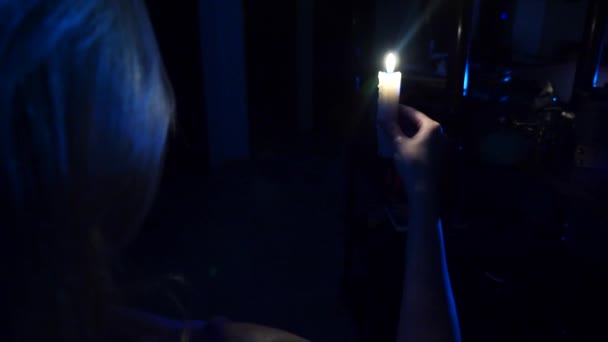 Žena chodí ve tmě domu se svíčkou v ruce. Halloween. Hrůza. 4 k. Zpomalený pohyb — Stock video