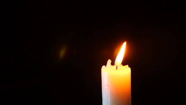 蜡烛在黑色的特写。濒临灭绝的一个白色的蜡烛火焰。烟从灯芯。4 k.慢动作拍摄 — 图库视频影像