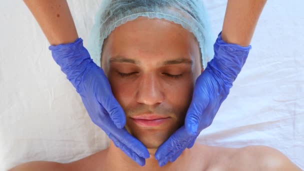 Spa therapy for handsome men receiving facial mask. 4k. Slow motion. Reception of a cosmetologist — Stock Video