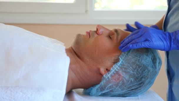 Spa therapie voor knappe mannen ontvangen gezichtsmasker. 4 k. Slow-motion. Ontvangst van een schoonheidsspecialist — Stockvideo