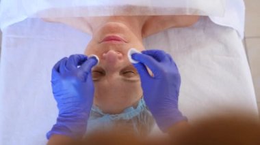 Yaşlı kadın yüz maskesi alma için Spa terapi. 4 k. ağır çekim. Bir güzellik uzmanı alımı