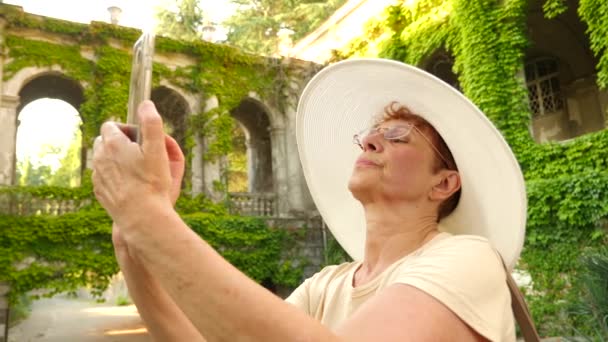 Belle femme âgée ou touriste prenant une photo avec téléphone portable smartphone. Dame de partager des photos sur le site de photo des médias sociaux. 4k. Mouvement lent — Video