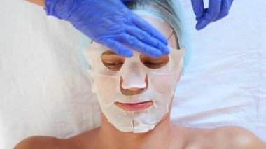 Yakışıklı erkekler yüz maskesi alma için spa terapisi. 4 k. ağır çekim. Bir güzellik uzmanı alımı
