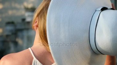 Güzel bir kadın onu şapka ve styling saç açık havada alır. Ağır çekim. Parkta eğleniyor, doğanın keyfini, Rüzgar ile oynarken mutlu sakin kız uzun saçlı. Yakın çekim. 4k