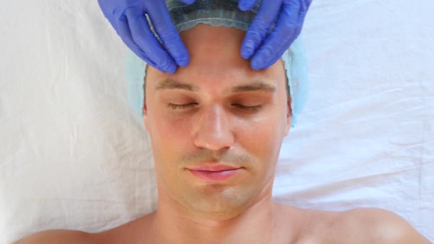 Spa therapy for handsome men receiving facial mask. 4k. Slow motion. Reception of a cosmetologist — Stock Video