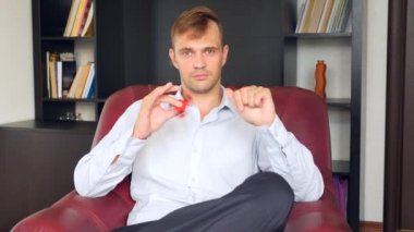 Kırmızı el spinner veya üzerinde dönen fidgeting spinner el mans. Onun masasında ofisinde topluca spinner iplik elbiseli adam. Burun üzerinde katlanmış. 4 k. ağır çekim