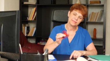 Kırmızı el spinner veya üzerinde dönen fidgeting spinner el mans. Yaşlı bayan işadamı topluca getiriyor onun masasında ofisinde iplik. 4 k. ağır çekim
