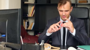 Kırmızı el spinner veya üzerinde dönen fidgeting spinner el mans. Onun masasında ofisinde topluca spinner iplik elbiseli adam. Burun üzerinde katlanmış. 4 k. ağır çekim