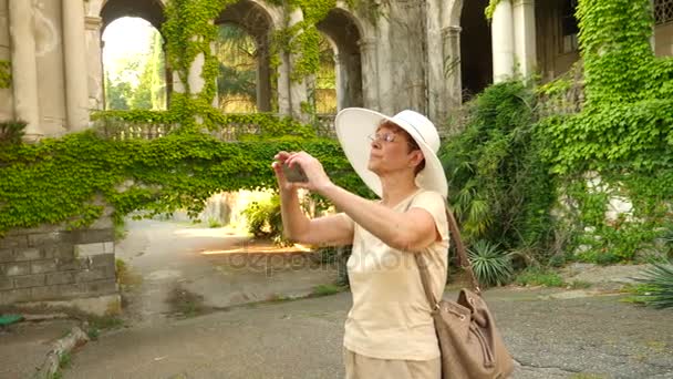 Hermosa anciana o turista tomando una fotografía con teléfono móvil. Señora para compartir foto en las redes sociales sitio de fotos. 4k. Movimiento lento — Vídeos de Stock