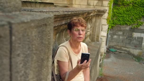 Hermosa anciana o turista tomando una fotografía con teléfono móvil. Señora para compartir foto en las redes sociales sitio de fotos. 4k. Movimiento lento — Vídeos de Stock