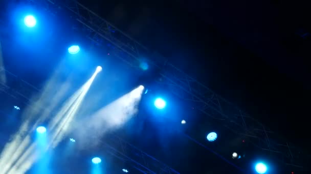 Дым от дымовой машины во время выступления на сцене рок-группы при свете прожекторов. 4K — стоковое видео