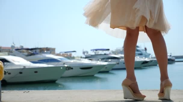 Femme en chapeau et lunettes de soleil sur le fond fait baie selfie avec des yachts. Fille en jupe-le soleil tourne et se réjouit. 4k au ralenti . — Video