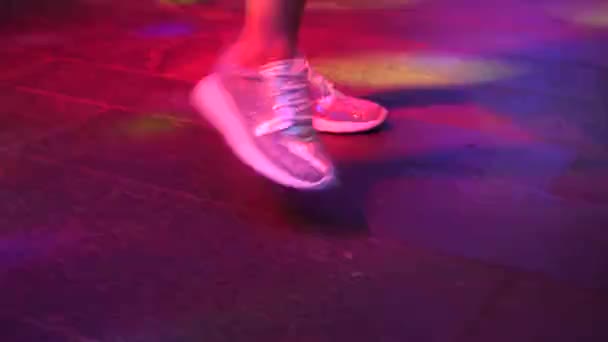 Womens benen in zilveren schoenen dansen op de dansvloer in de discobar. Licht van safitov. 4k — Stockvideo