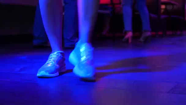 Frauenbeine in silbernen Schuhen tanzen auf der Tanzfläche in der Discobar. Licht von safitov. 4k — Stockvideo