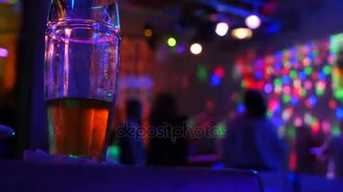 Bir kupa bira disko bar dans eden insanlar arka planı tablo ile bitirmek değil. 4k.