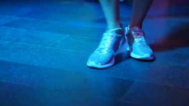 Bayan bacaklar, gümüş rengi ayakkabı disco barda dans pistinde dans ediyor. Safitov gelen ışık. 4k
