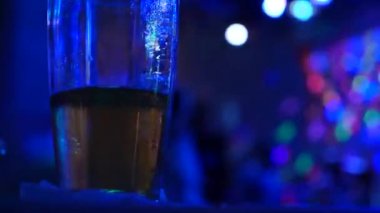 Bir kupa bira disko bar dans eden insanlar arka planı tablo ile bitirmek değil. 4k.