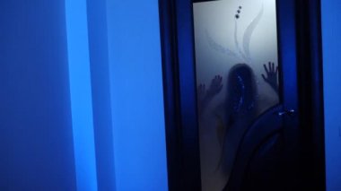 Evde bir hayalet kız. Küçük bir kızın ruhu. Korkunç sahne korkunç bir kadın. Zombi şeffaf kapı çalıyor. 4 k. ağır çekim