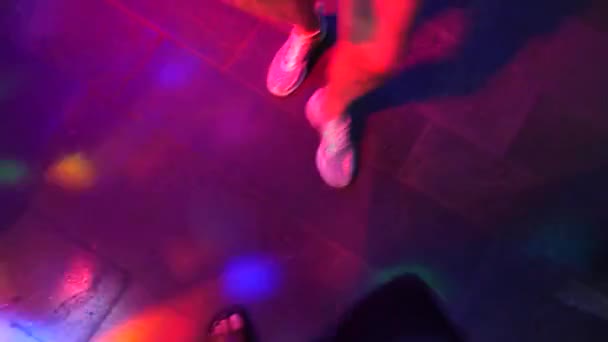 Dámské nohy v stříbrné boty se tančí na tanečním parketu v disco baru. Světlo z safitov. 4k