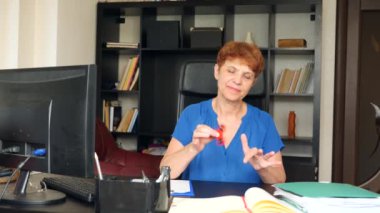 Kırmızı el spinner veya üzerinde dönen fidgeting spinner el mans. Yaşlı bayan işadamı topluca getiriyor onun masasında ofisinde iplik. 4 k. ağır çekim