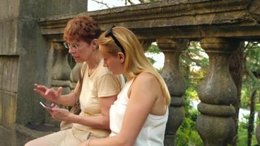 Genç kadın, anne ve kızı, smartphone cep telefonu ile çekilen fotoğraf ile güzel kadın kıdemli. Turistik yerleri görüntüleyin. 4 k. ağır çekim