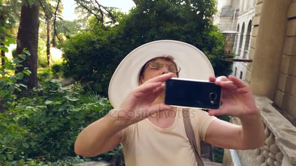 Mooie oudere vrouw of toerist een foto met mobiele gsm smartphone. Lady delen pic op sociale media fotosite. 4 k. Slowmotion — Stockvideo